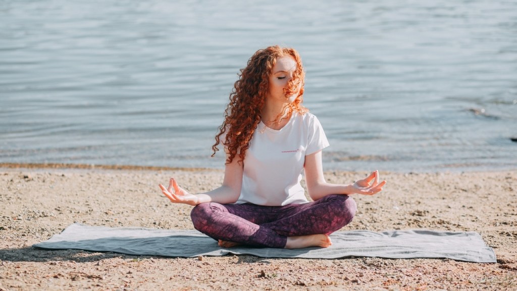 Woman meditating on beach and contacting her higher self