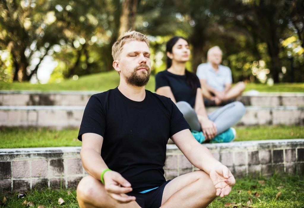 People practicing yoga in a park