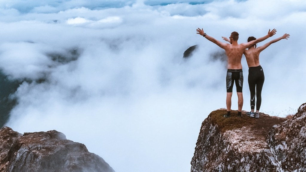 Man and woman standing on a cliff taking risks
