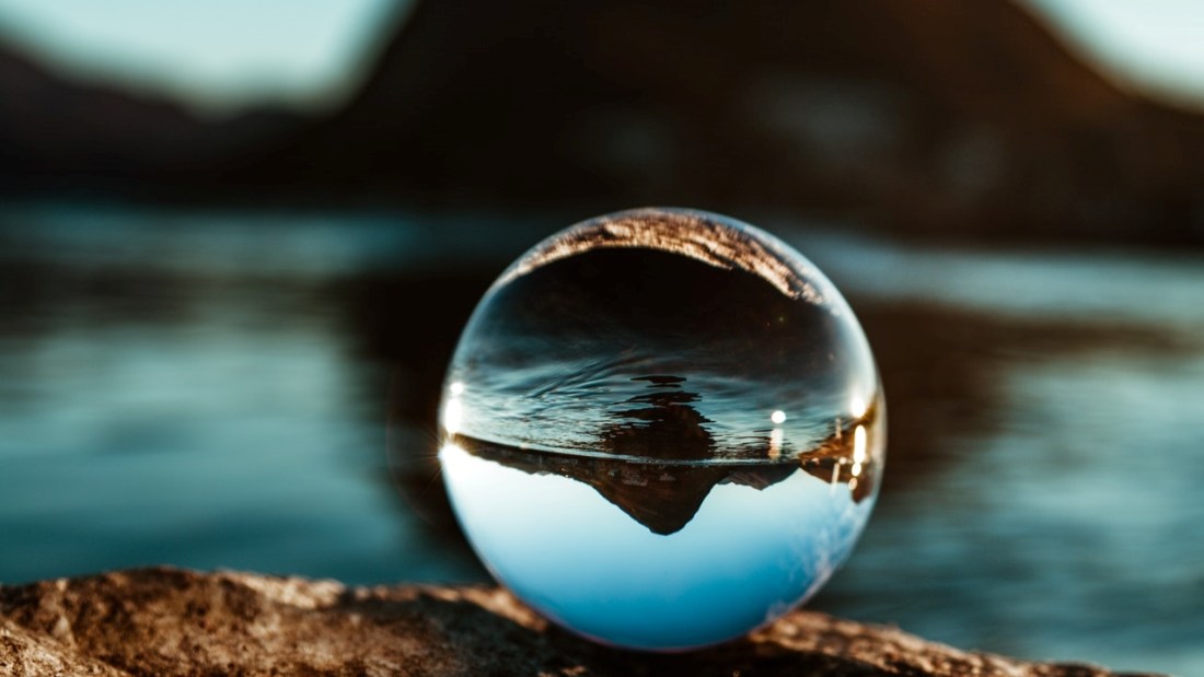 Crystal ball focusing sea and mountain now