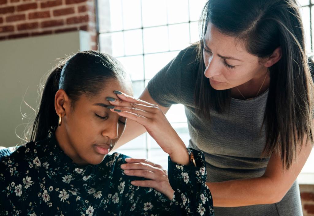 Woman with migraine headache touching her forehead