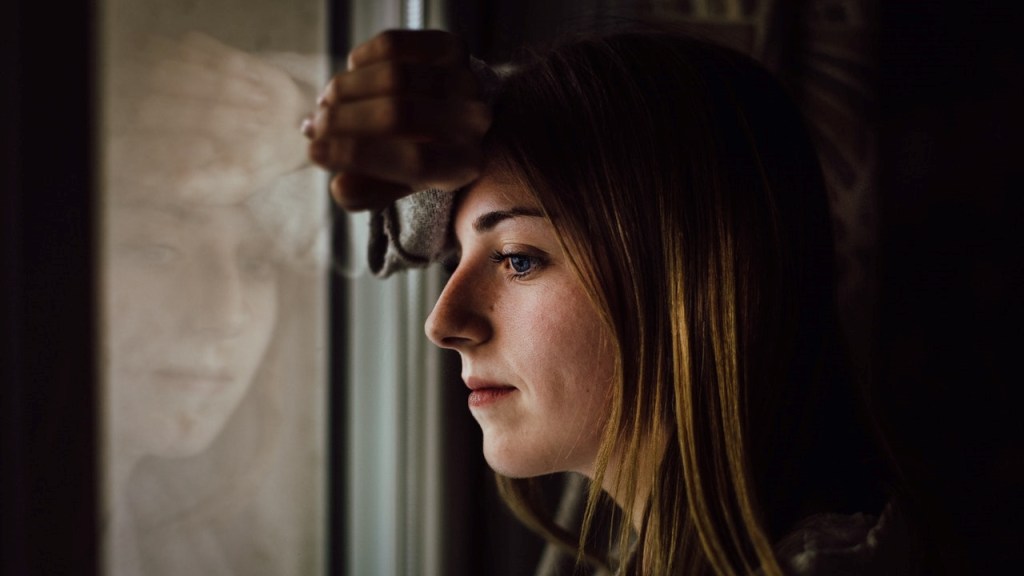 Depressed woman looking out a window