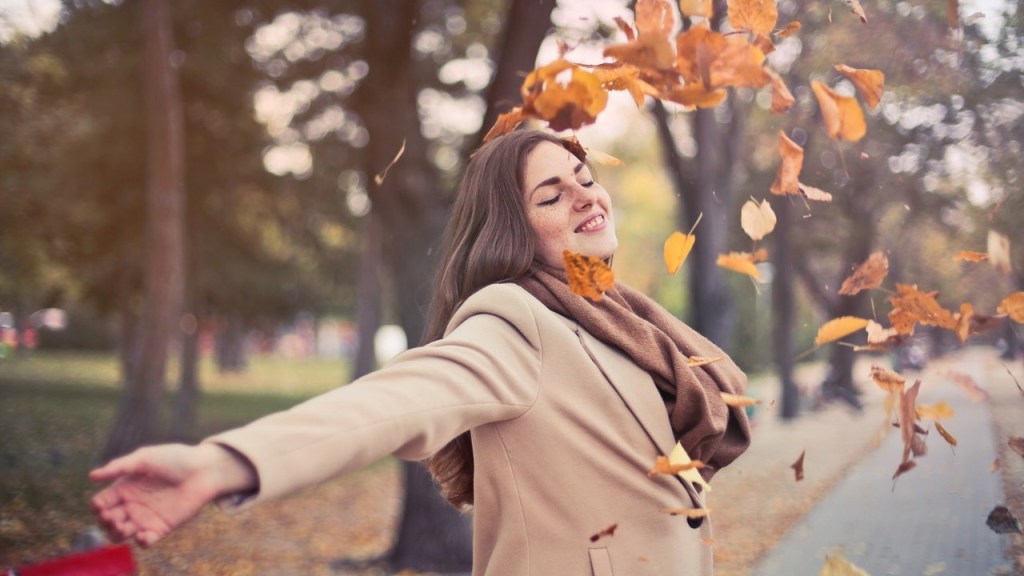 Healthy woman playing in winter leaves