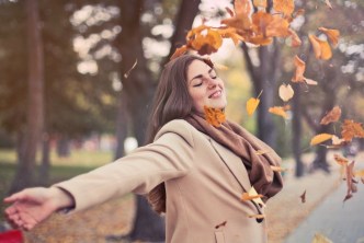Healthy woman playing in winter leaves