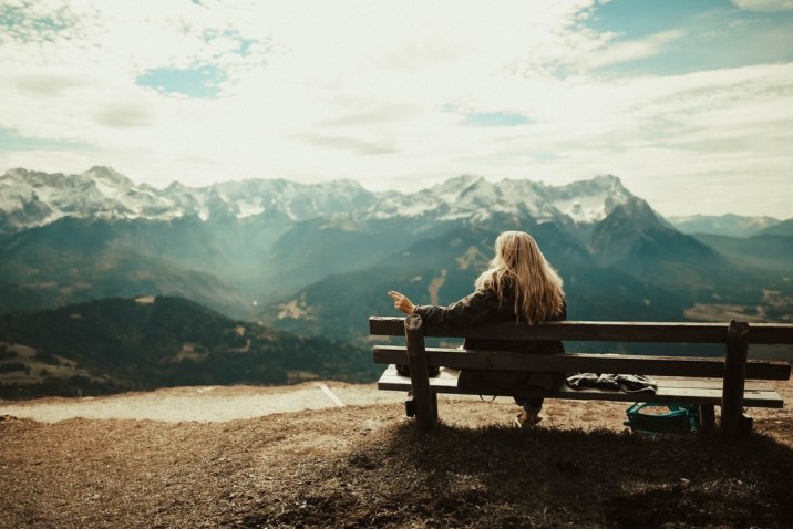 Woman on bench looking at mountains - Being and Enlightenment