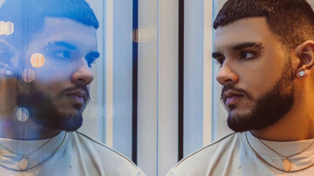 A man looking at himself reflected in a window.