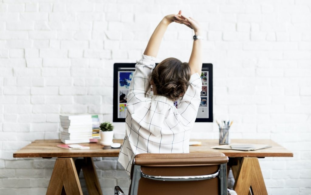 Woman stretching at her computer