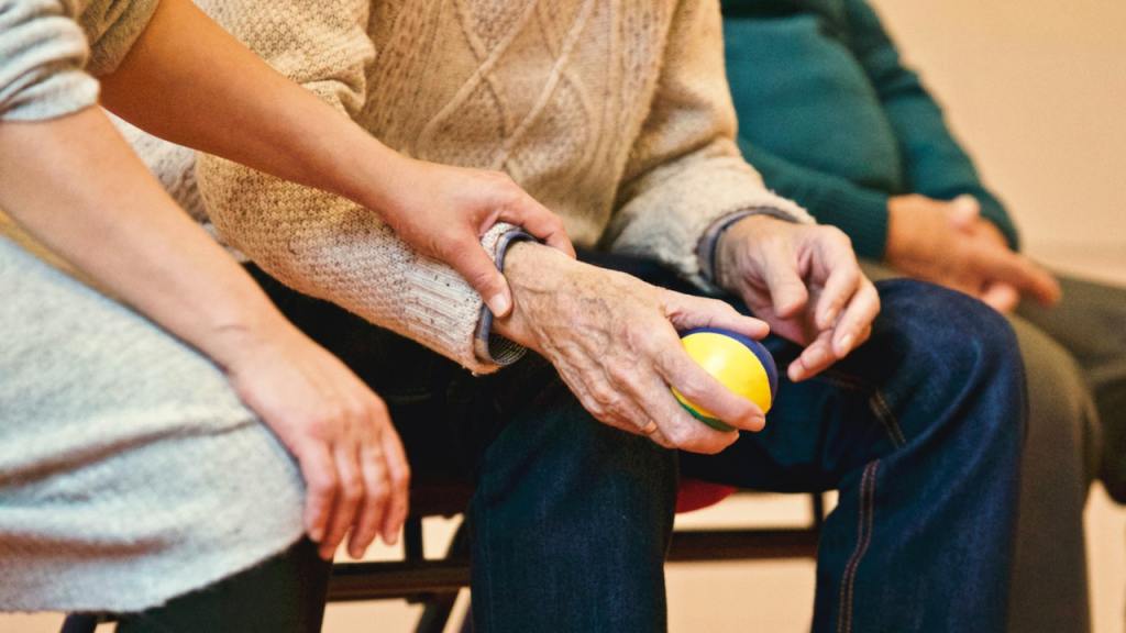 Caregiver holding hand of elderly patient