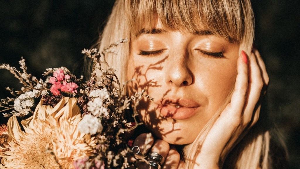 Vibrant healthy woman smelling flowers