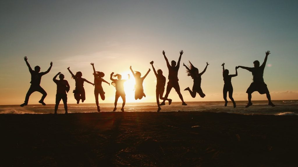 People letting their inner child out and jumping on a beach