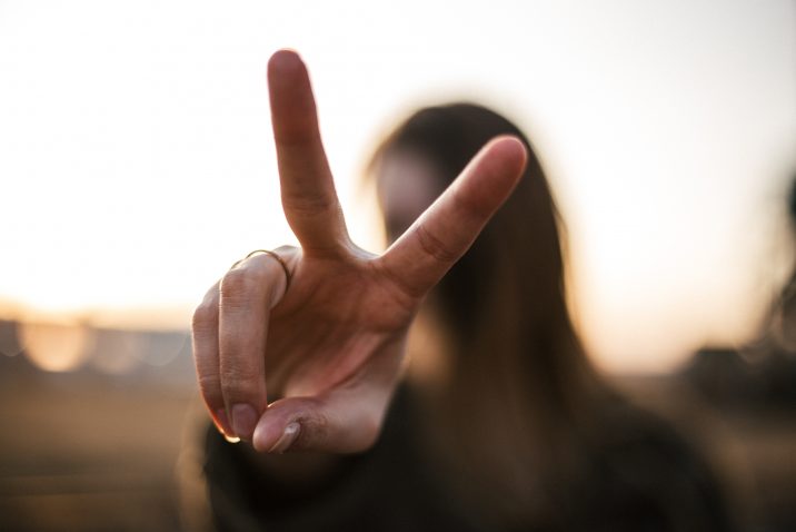 A woman making the peace sign