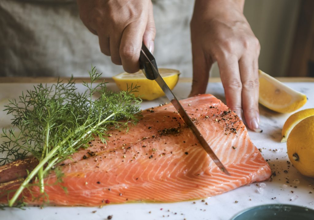 A man slicing raw salmon