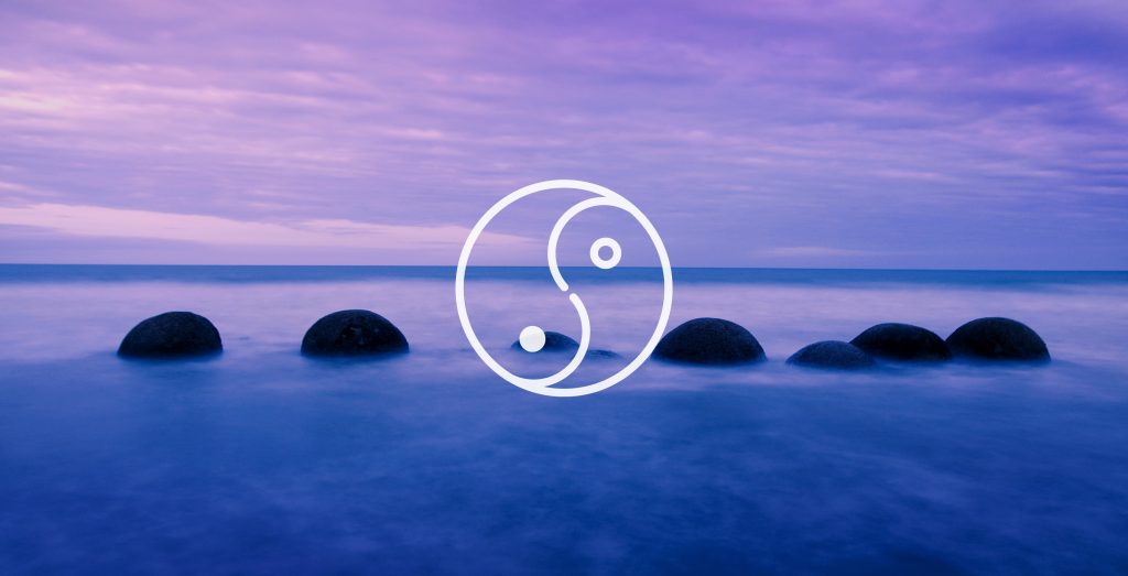 Ying Yang overlaid on top of rocks in the ocean