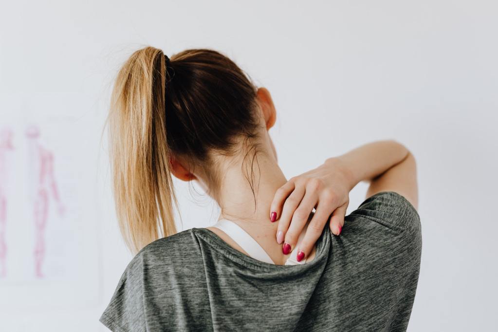 Woman rubbing her back - Listening to Your Symptoms