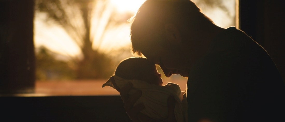 Man holding and selflessly loving a baby